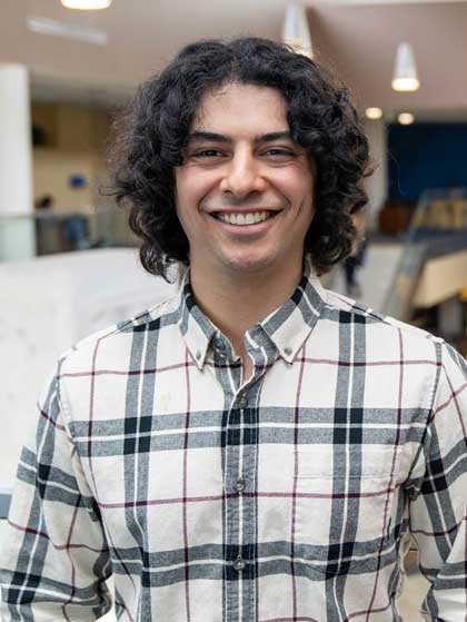 Evan smiles for the camera, as he stands above the Pylons area of the Health Sciences Center lobby in Morgantown.