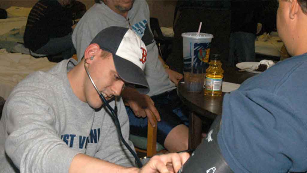 A student exams a member of the community.